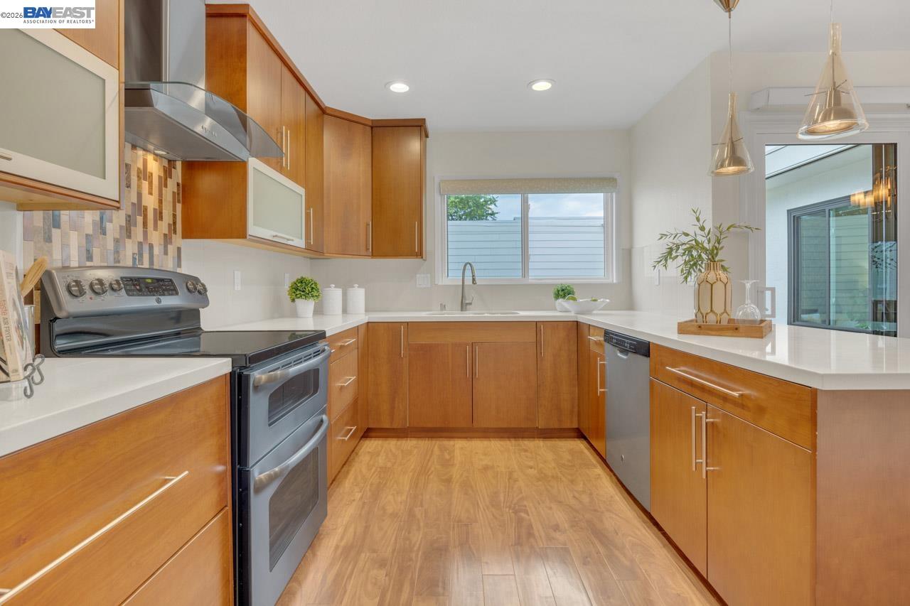 4034 Rennellwood Way Pleasanton, CA 94566 - Photo 24 of 42 a kitchen with stainless steel appliances granite countertop wooden cabinets a sink a stove a dining table and chairs