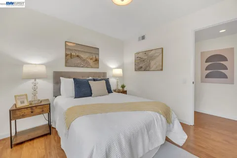a bedroom with a bed and a potted plant on dresser