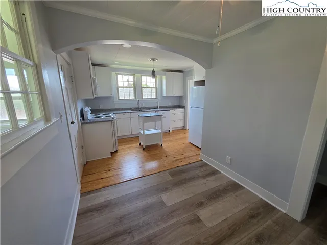 a view of kitchen and hall with wooden floor