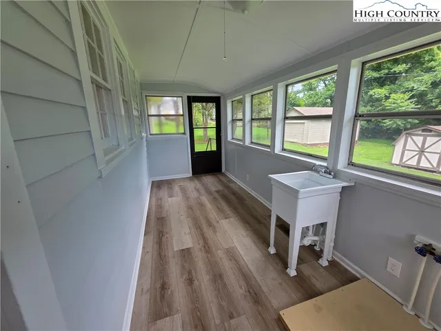 a view of a hallway with wooden floor and furniture