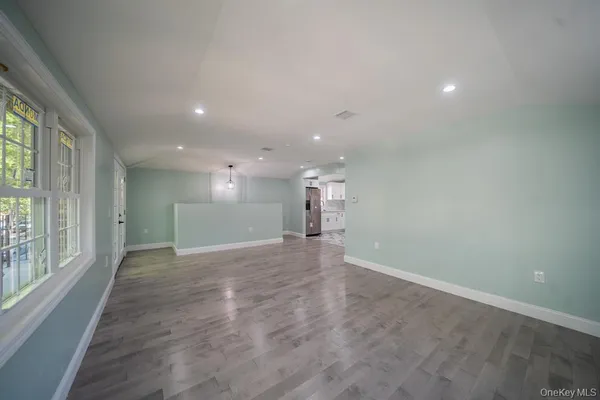 a view of a big room with windows and chandelier fan