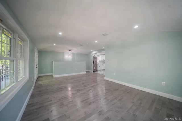 a view of a big room with windows and chandelier fan