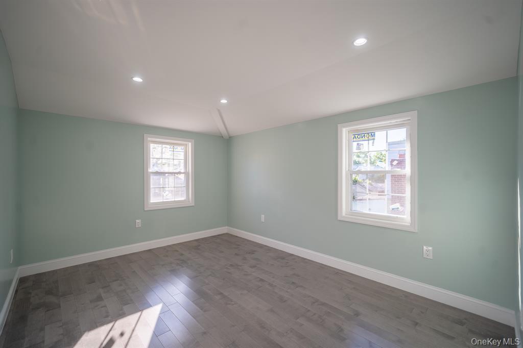115-42 Inwood Street, Unit 2 Queens, NY 11436 - Photo 4 of 14 a view of an empty room with a window and wooden floor