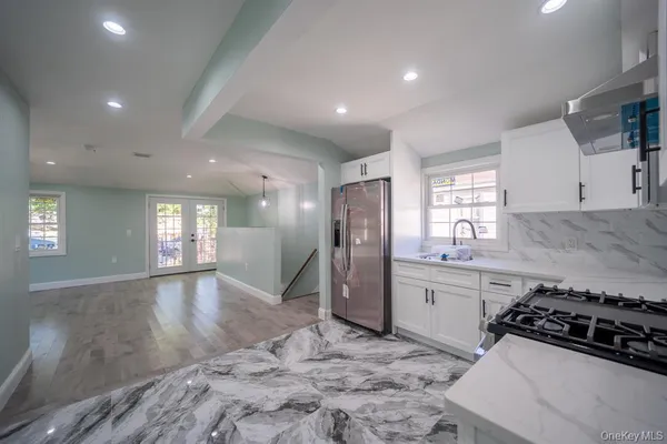 a kitchen with stainless steel appliances granite countertop a sink stove and refrigerator