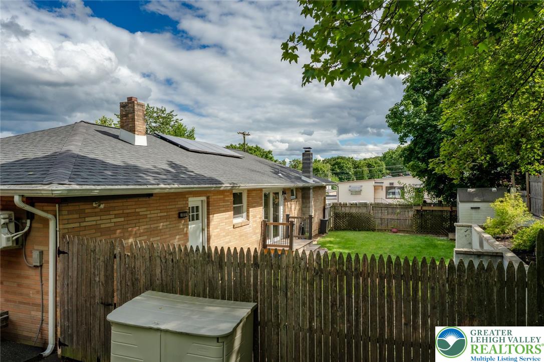 402 Maple Street Roseto, PA 18013 - Photo 33 of 39 Enclosed wood fencing frames a grassy lawn behind this classic single-level brick residence.