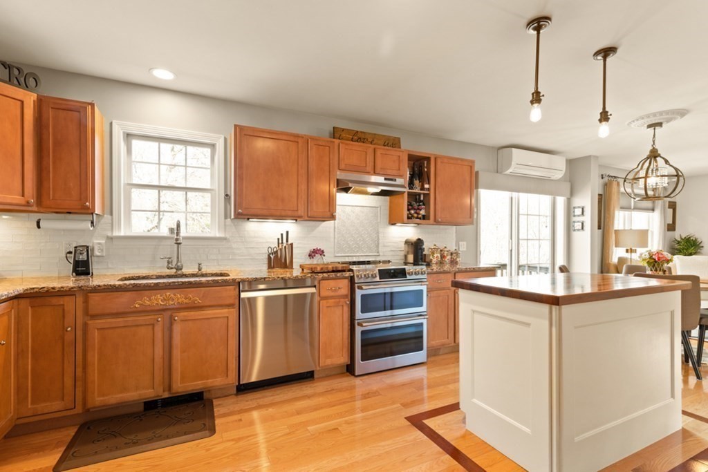 82 Hammersmith Drive Saugus, MA 01906 - Photo 20 of 41 a kitchen with stainless steel appliances granite countertop wooden cabinets a sink dishwasher a stove and a refrigerator with wooden floor