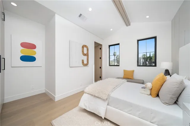 a bedroom with a bed and painting on the wall