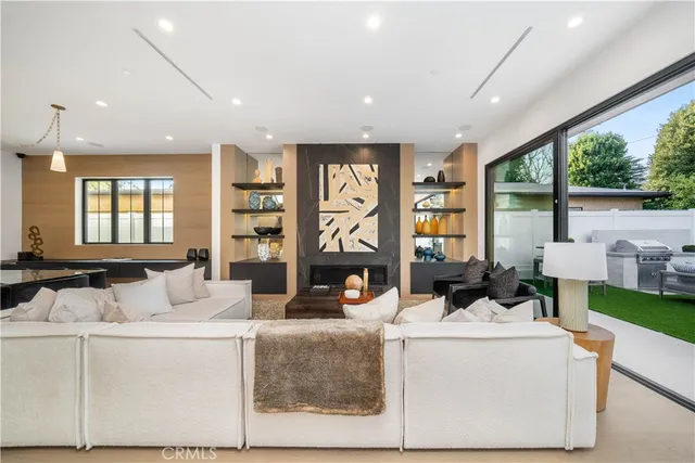 a living room with fireplace furniture and a large window