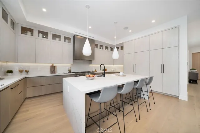 a kitchen with a sink and chairs