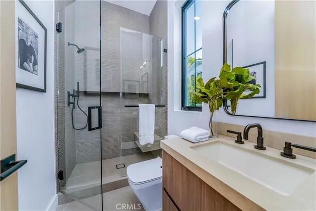 a bathroom with a granite countertop sink a toilet and shower