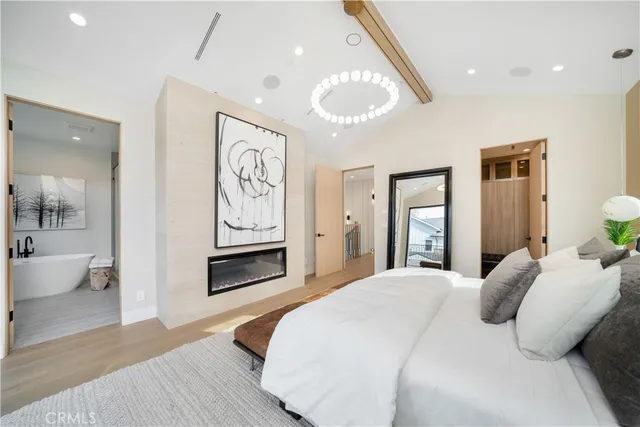 a bedroom with a large bed and a chandelier