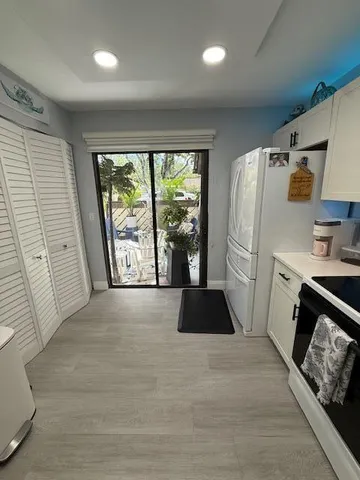 a kitchen with a refrigerator a stove top oven and a large window