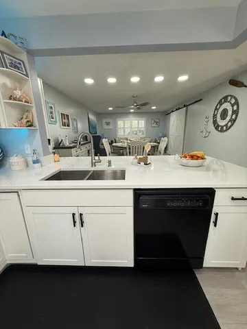a kitchen with kitchen island a sink stainless steel appliances and cabinets