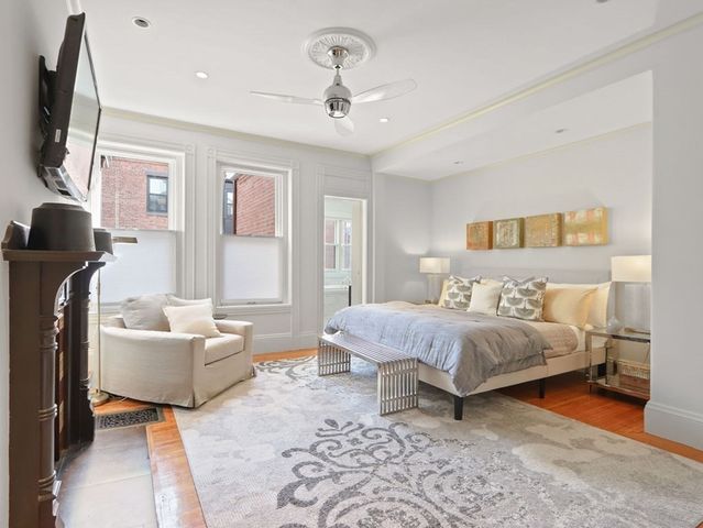 a spacious bedroom with a bed and a flat screen tv