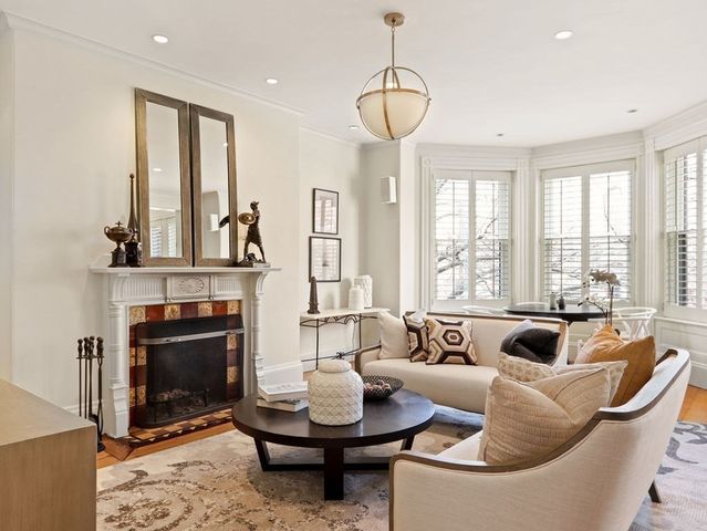 a living room with furniture a fireplace and a chandelier