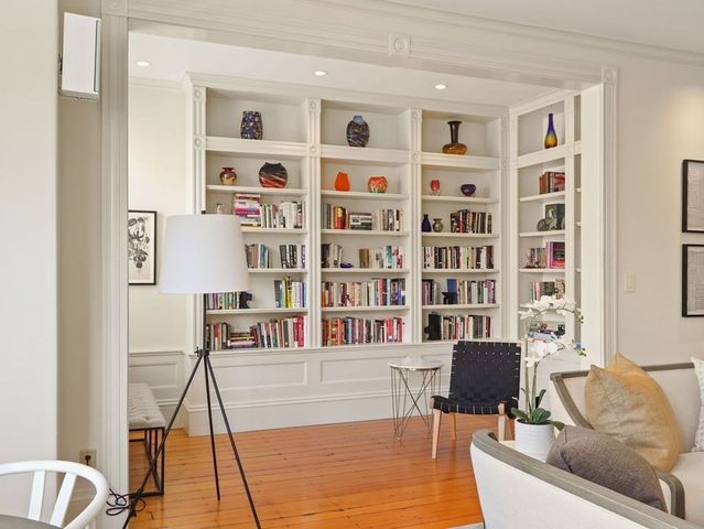 a living room with furniture and a book shelf