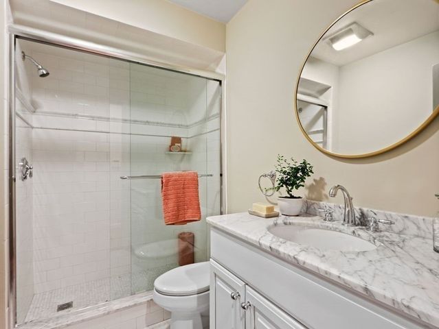 a bathroom with a granite countertop sink toilet and a mirror