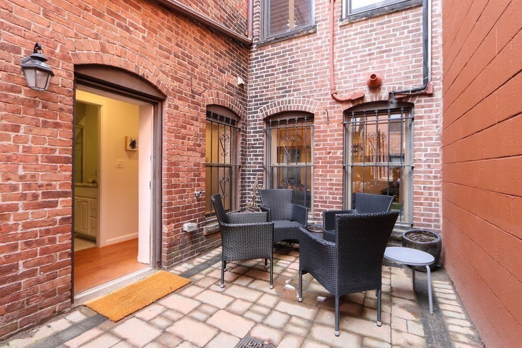 138 St Botolph Street Boston, MA 02115 - Photo 37 of 39 a view of a patio with table and chairs and wooden floor