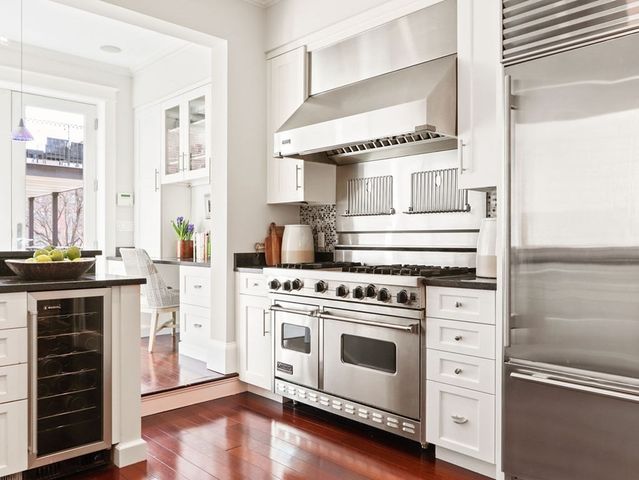 a kitchen with a stove and white cabinets