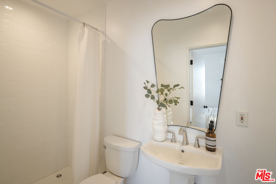 8420 Cresthill Road Los Angeles, CA 90069 - Photo 12 of 30 a bathroom with a sink a toilet and a mirror