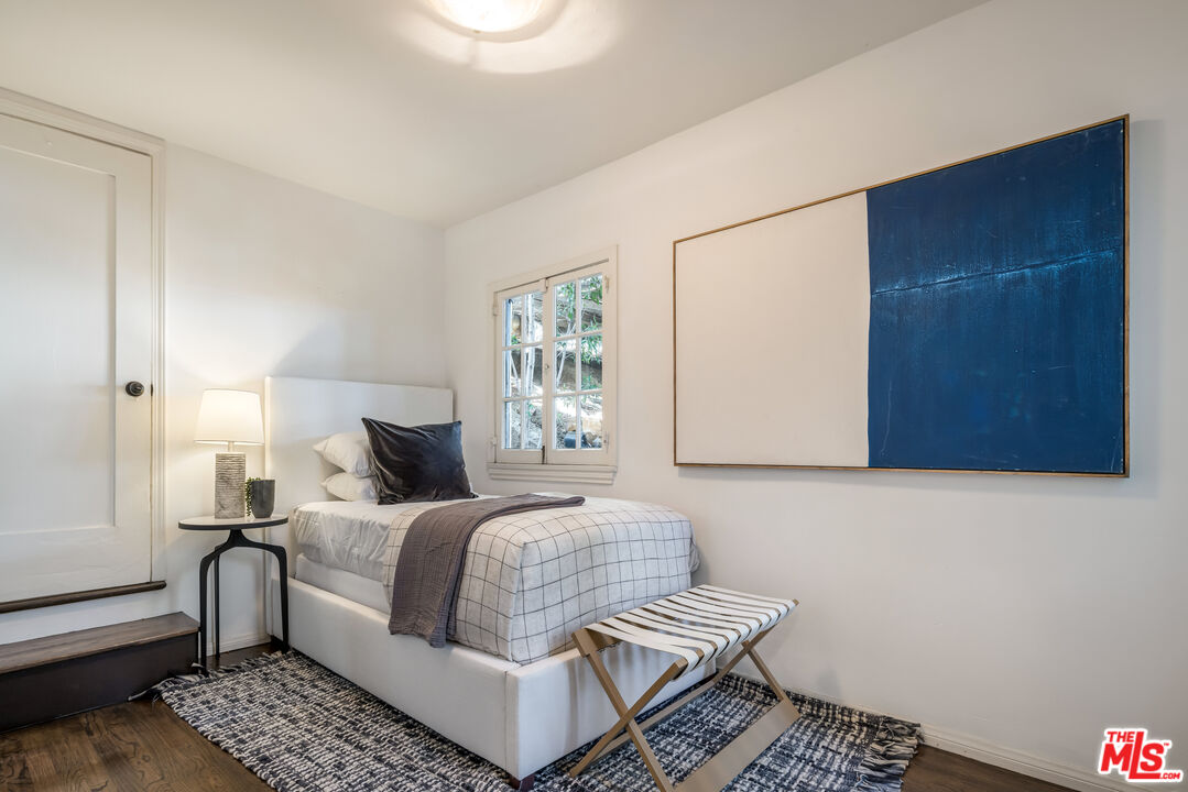 8420 Cresthill Road Los Angeles, CA 90069 - Photo 20 of 30 a bedroom with a bed and wooden floor