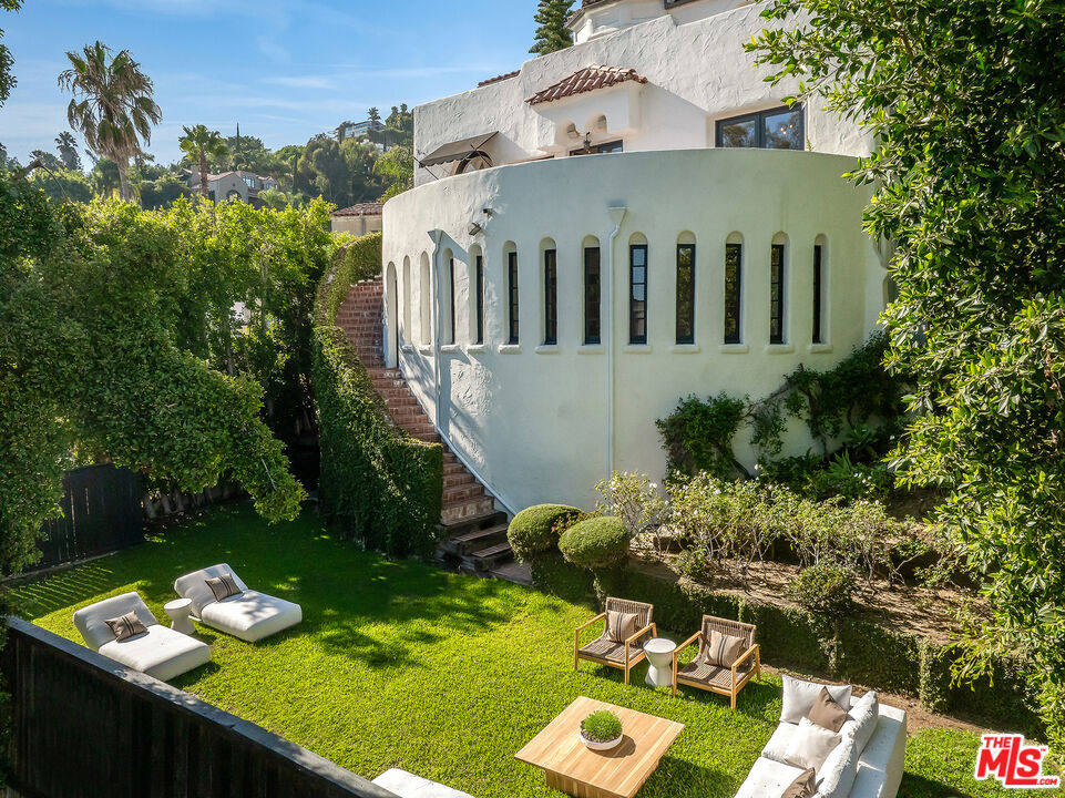 8420 Cresthill Road Los Angeles, CA 90069 - Photo 23 of 30 a view of a chairs and table in a backyard