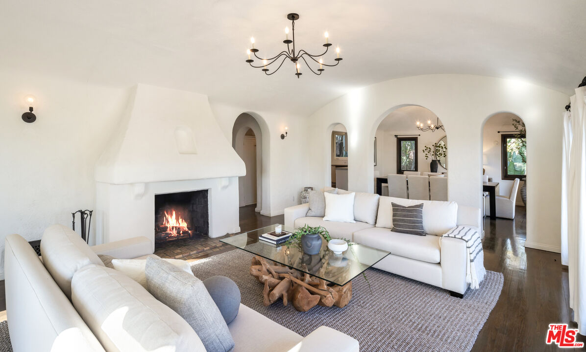 8420 Cresthill Road Los Angeles, CA 90069 - Photo 7 of 30 a living room with furniture a fireplace and a chandelier