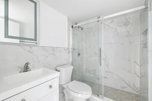 a bathroom with a sink a toilet and shower