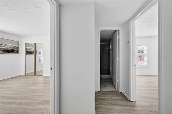 a view of a hallway with wooden floor and closet