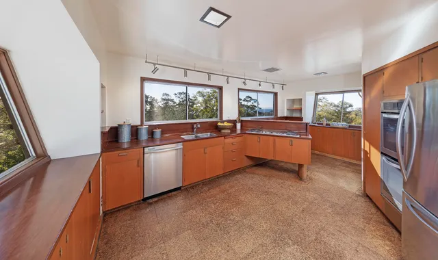 a kitchen with granite countertop a refrigerator stove top oven and sink
