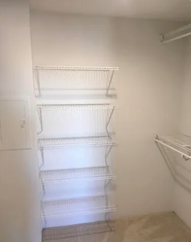 a view of walk in closet with empty racks