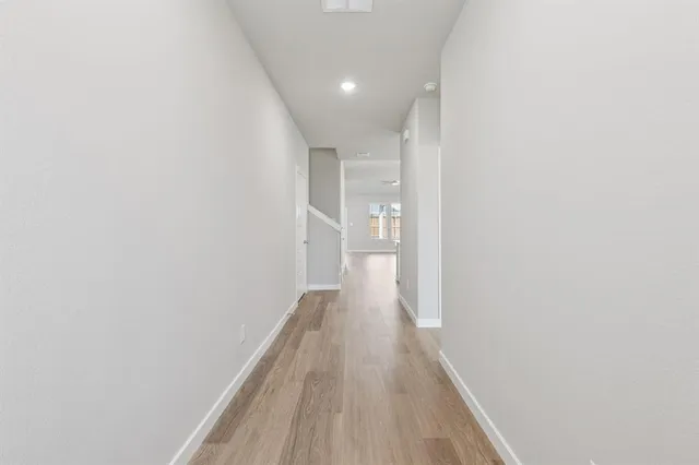 a view of a hallway with wooden floor
