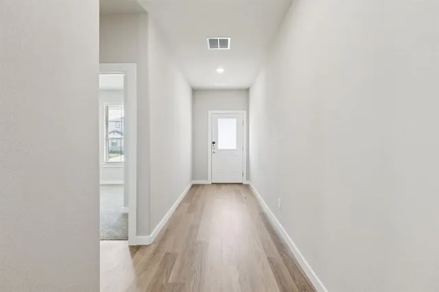 a view of a hallway with wooden floor