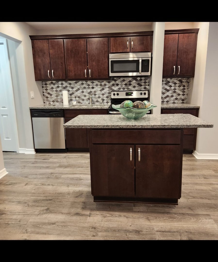 720 North Western Avenue, Unit 10 Park Ridge, IL 60068 - Photo 7 of 19 a kitchen with kitchen island granite countertop a stove a microwave a sink and cabinets