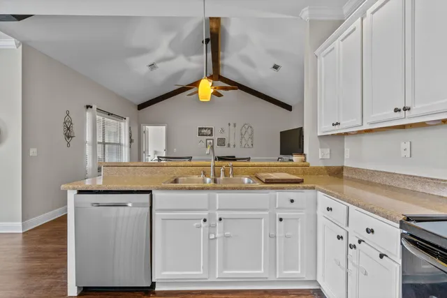 a kitchen with white cabinets and sink
