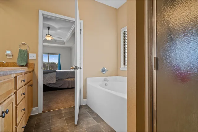 a en suite bathroom with a tub sink and mirror
