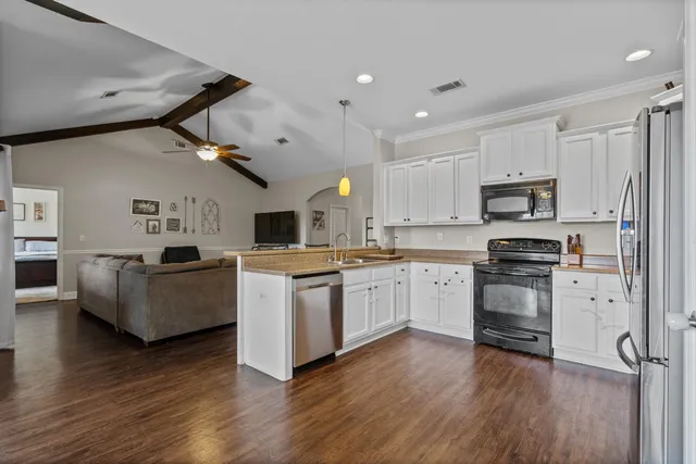 a kitchen with a refrigerator cabinets and wooden floor