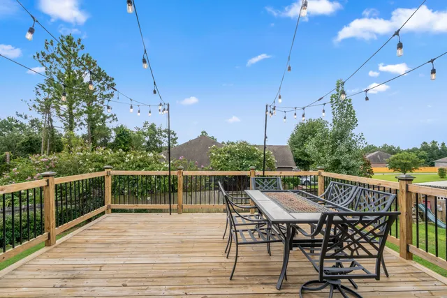 a view of a roof deck with table and chairs and wooden floor