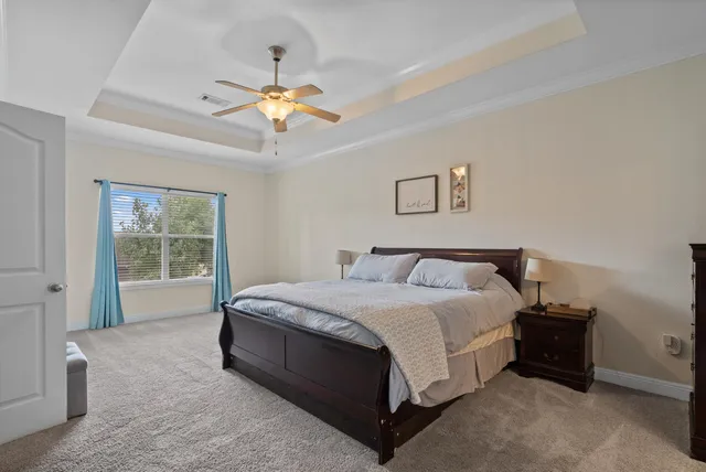 a spacious bedroom with a bed and a chandelier