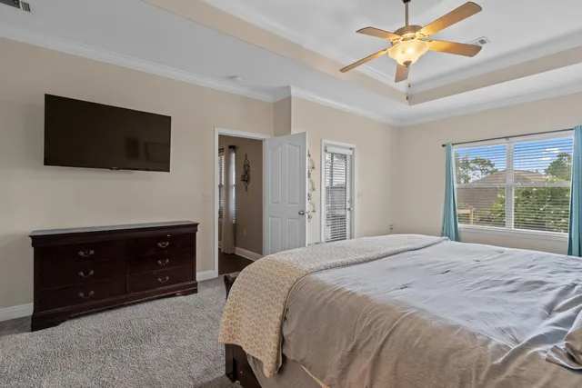 a bedroom with a bed a flat screen tv and a dresser