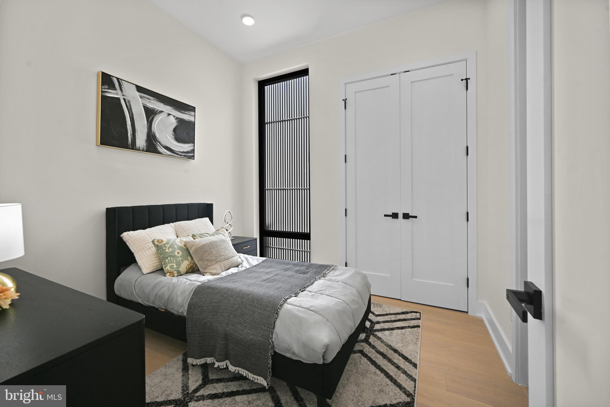 517 Montana Avenue Northeast, Unit 3C Washington, DC 20017 - Photo 13 of 54 a bedroom with a bed and a painting on the wall