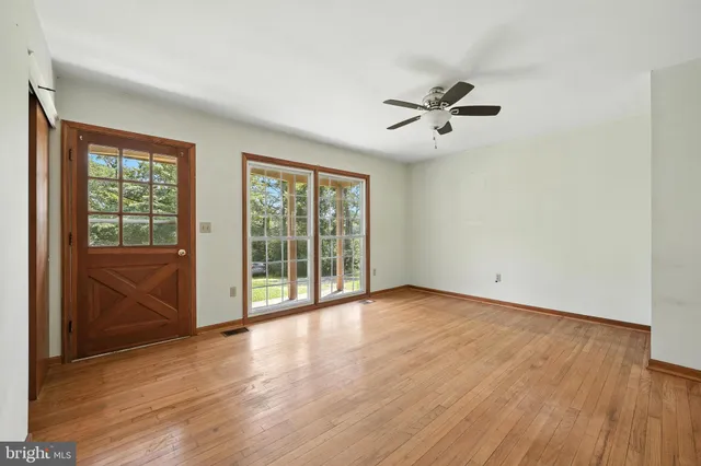 wooden floor in an empty room with a window