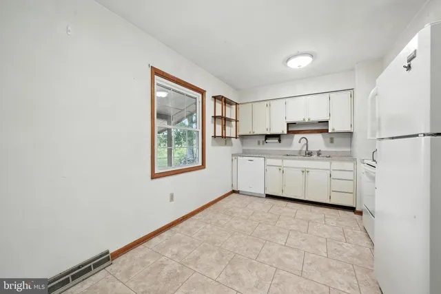 a kitchen with a cabinets a sink a window and a stainless steel appliances