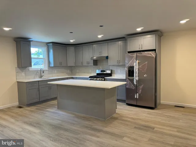 a kitchen with a refrigerator a sink and cabinets