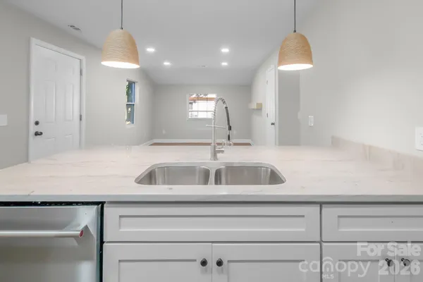 a kitchen with kitchen island a sink and a mirror