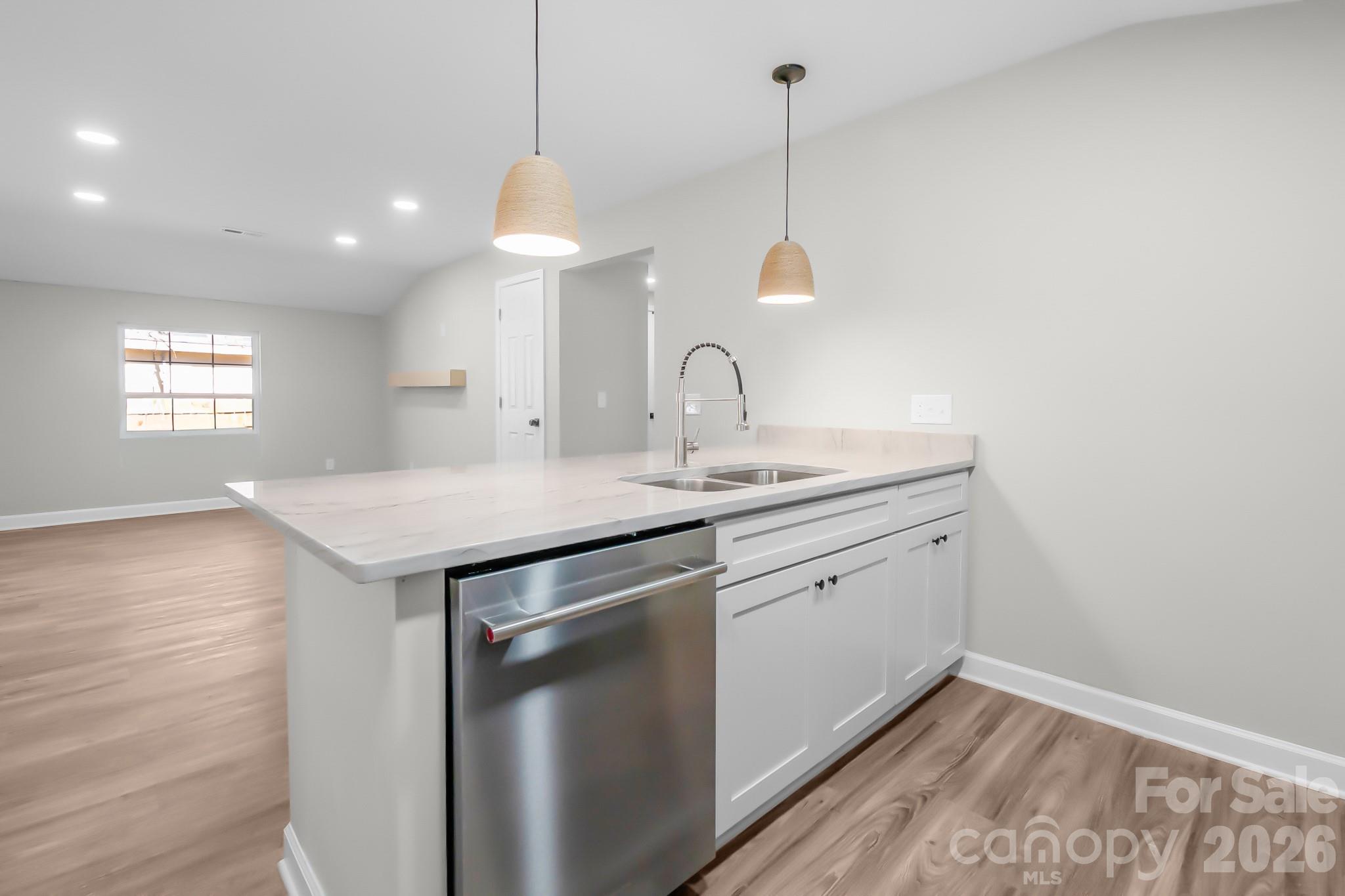 401 Golf Course Road Winnsboro, SC 29180 - Photo 15 of 39 a kitchen with a sink dishwasher and white cabinets with wooden floor