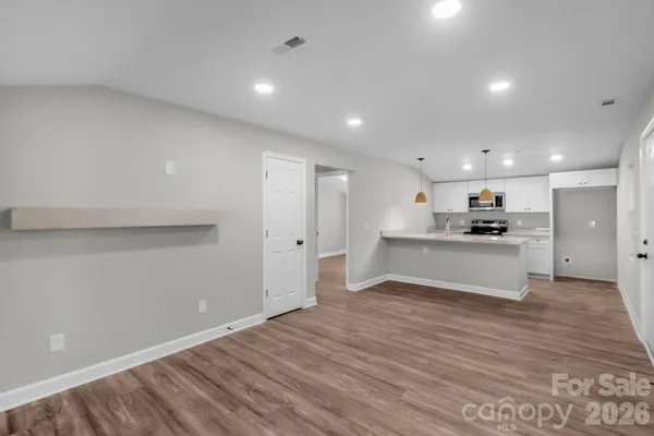 a view of kitchen with kitchen island white cabinets and wooden floor