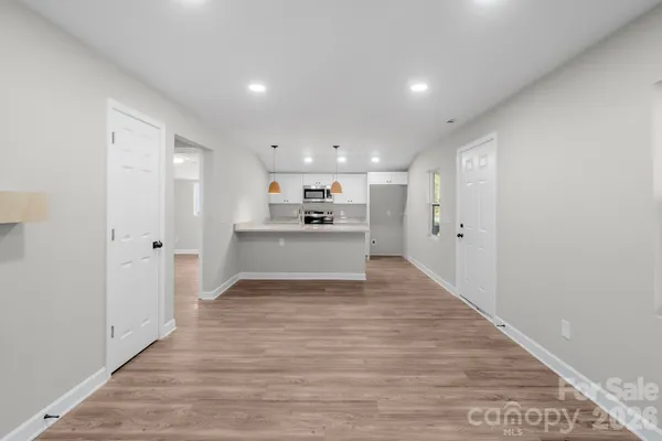 a view of a kitchen with a sink and wooden floor