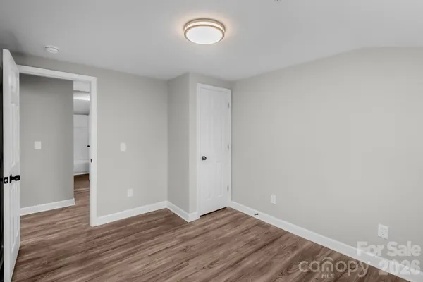 a view of a room with wooden floor and a window