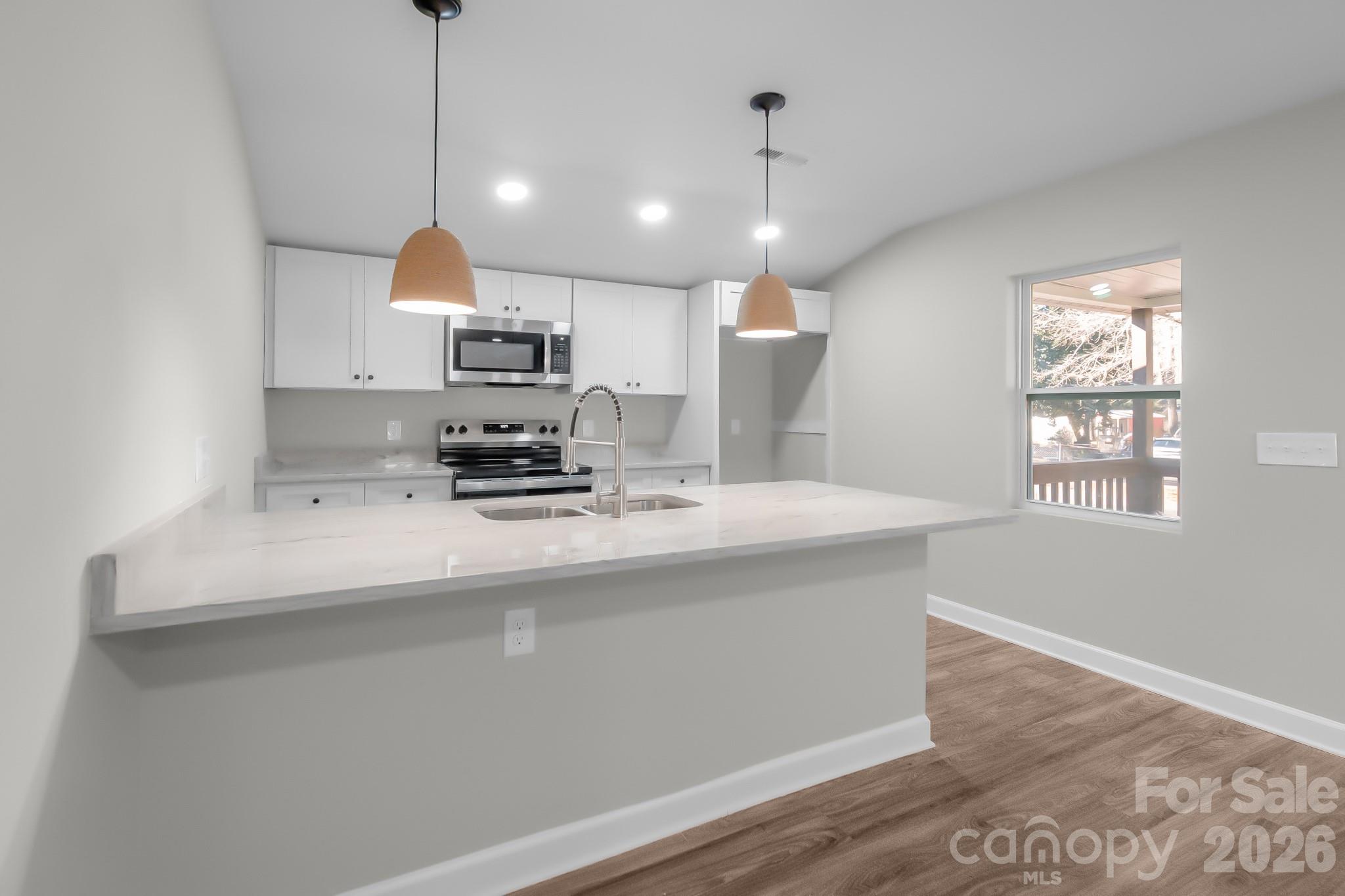 401 Golf Course Road Winnsboro, SC 29180 - Photo 9 of 39 a kitchen with kitchen island a sink stainless steel appliances and a window